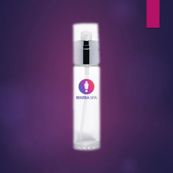 Clear glass cosmetic spray bottle with silver pump on purple background