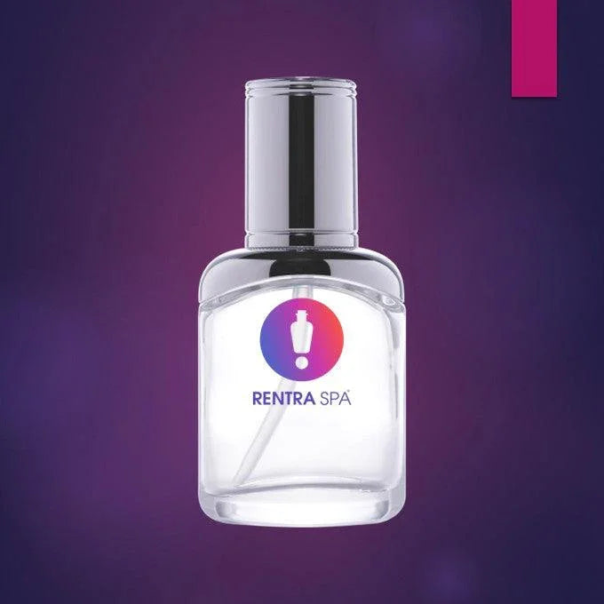 Clear glass cosmetic spray bottle with metallic cap on purple background