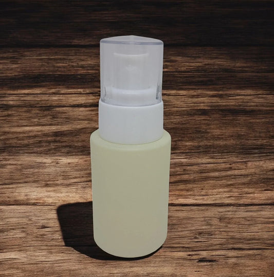Frosted glass cosmetic bottle with white pump dispenser on wooden background