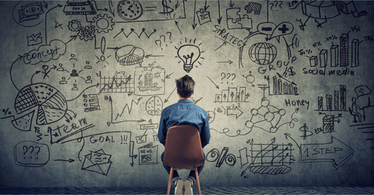 Person brainstorming with business strategy charts, graphs, and marketing doodles on wall